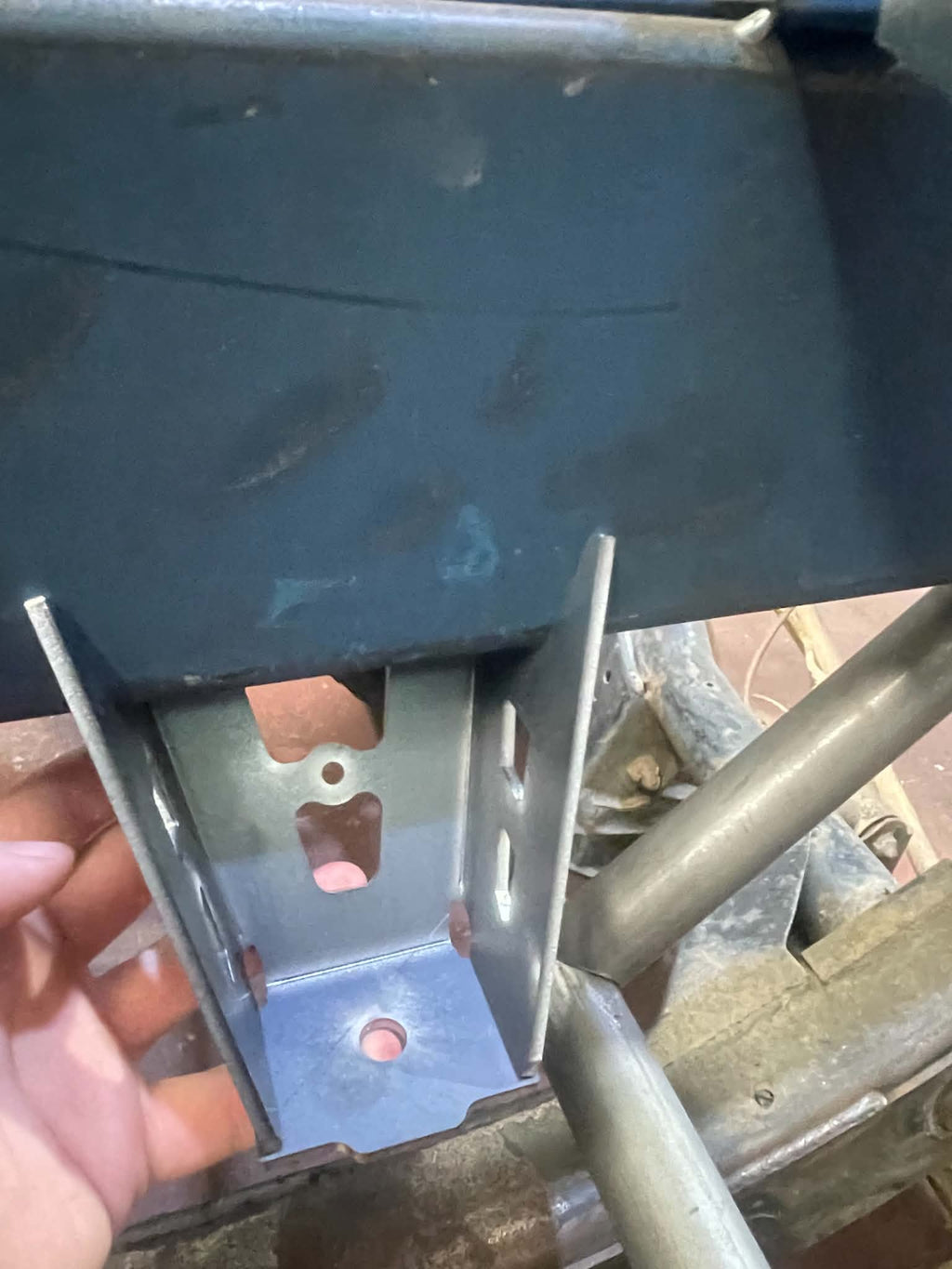 Upper tray mount underside showing bolt-on mounting point